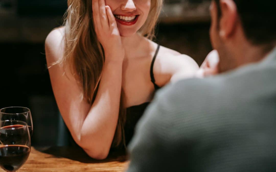 A woman on a first date. A man is facing her, but we can't see his face. It appears to be going well.