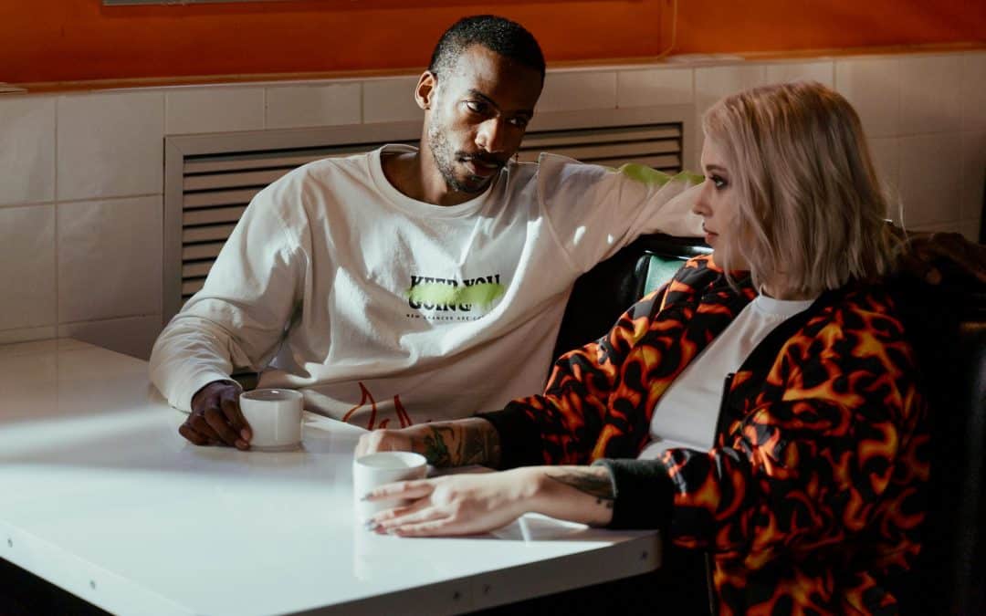 A couple in their early thirties having an important conversation over a cup to tea. It's something serious, but he is listening attentively